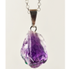 A closeup of an amethyst pendant with a silver plated bail. It's color is violet.