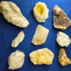 A group shot of 9 mineral specimens with a blue background.