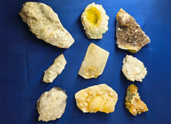 A group shot of 9 mineral specimens with a blue background.