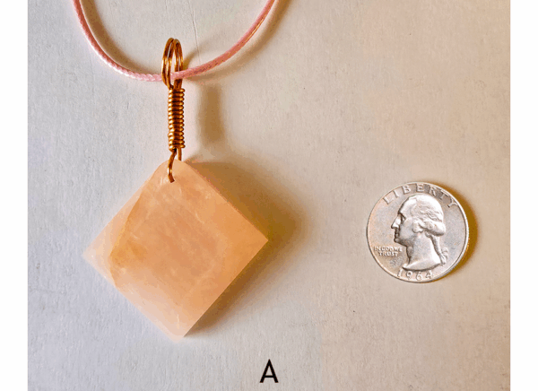 A pink rose quartz faceted pendant with a copper wire wrapped bail, and a quarter for size comparison. Labeled A.