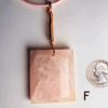 A pink rose quartz faceted pendant with a copper wire wrapped bail, and a quarter for size comparison. Labeled F.