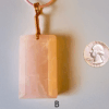 A pink rose quartz faceted pendant with a copper wire wrapped bail, and a quarter for size comparison. Labeled B.