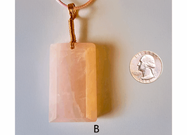 A pink rose quartz faceted pendant with a copper wire wrapped bail, and a quarter for size comparison. Labeled B.